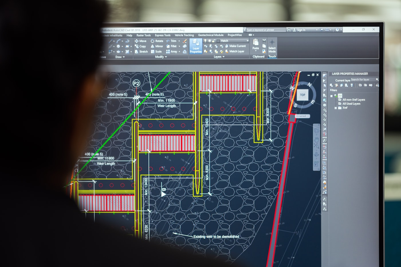 A monitor showing a detailed 2D CAD plan drawing with coloured linework and dimensions