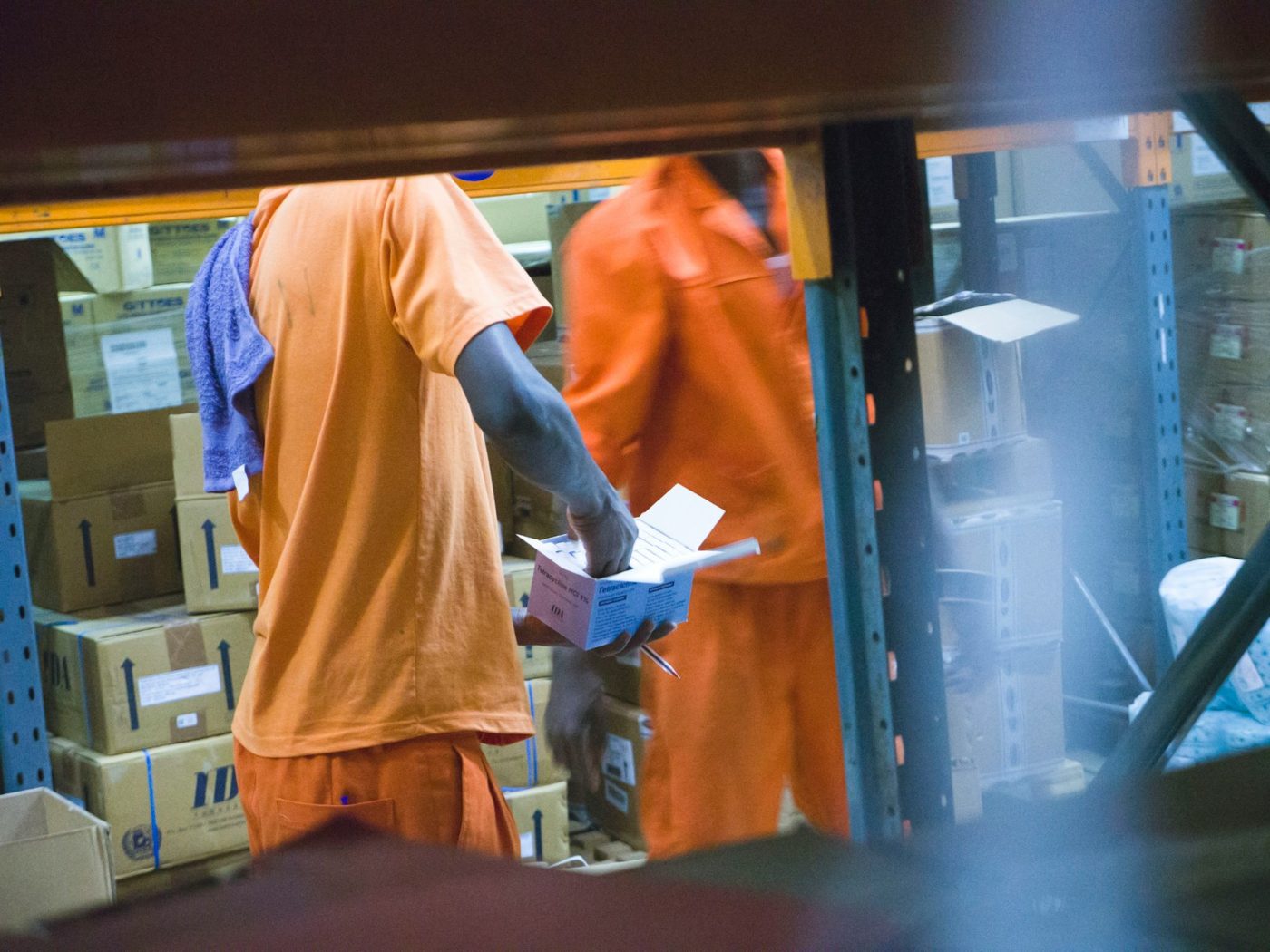 Workers handling packed cartons at a distribution bay